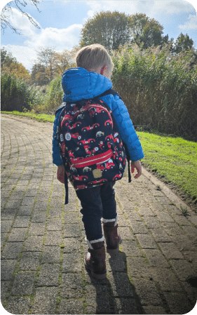 Das Kind trägt denselben Rucksack im Freien